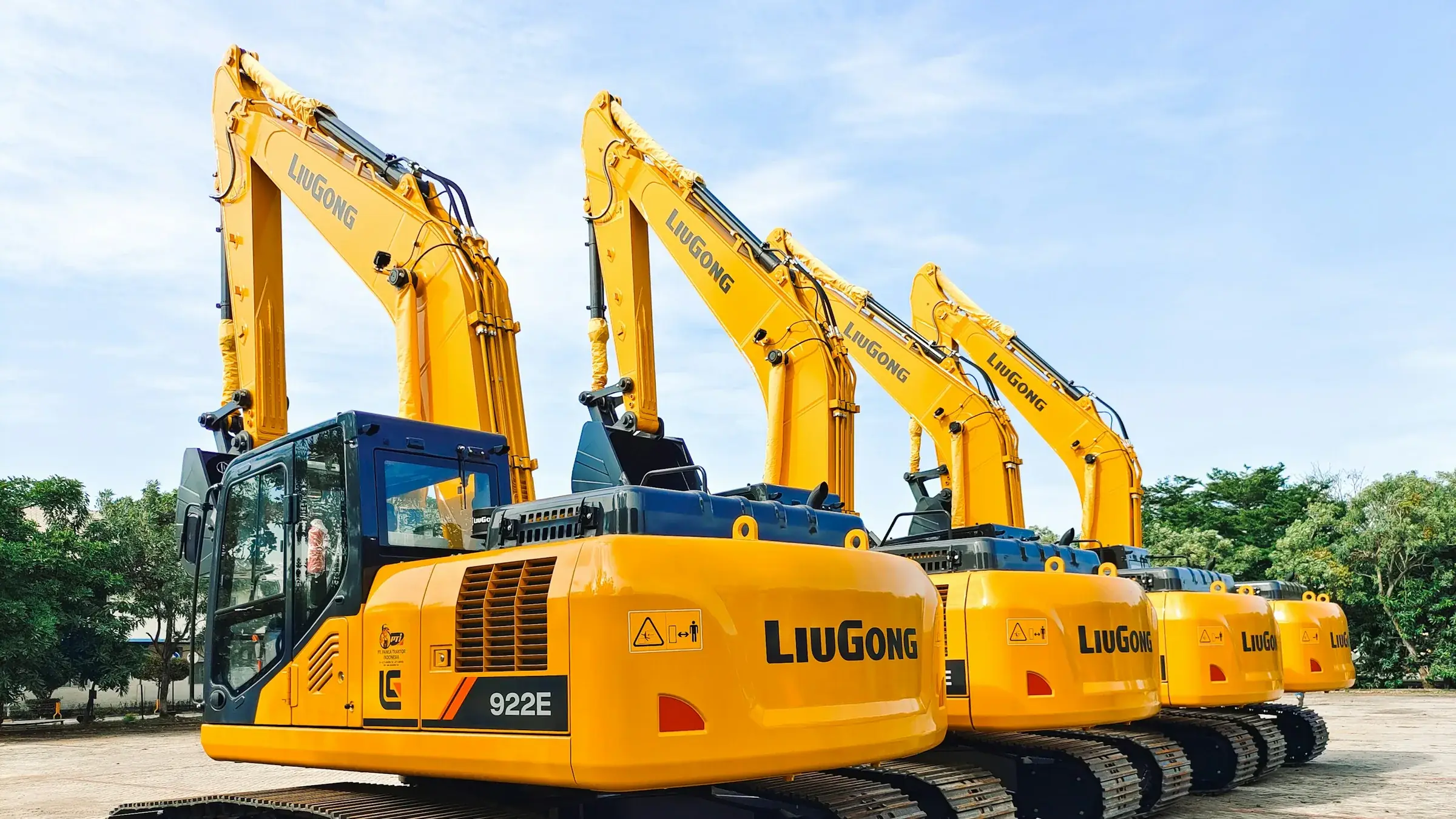 Row of yellow and blue construction excavators staged at a worksite